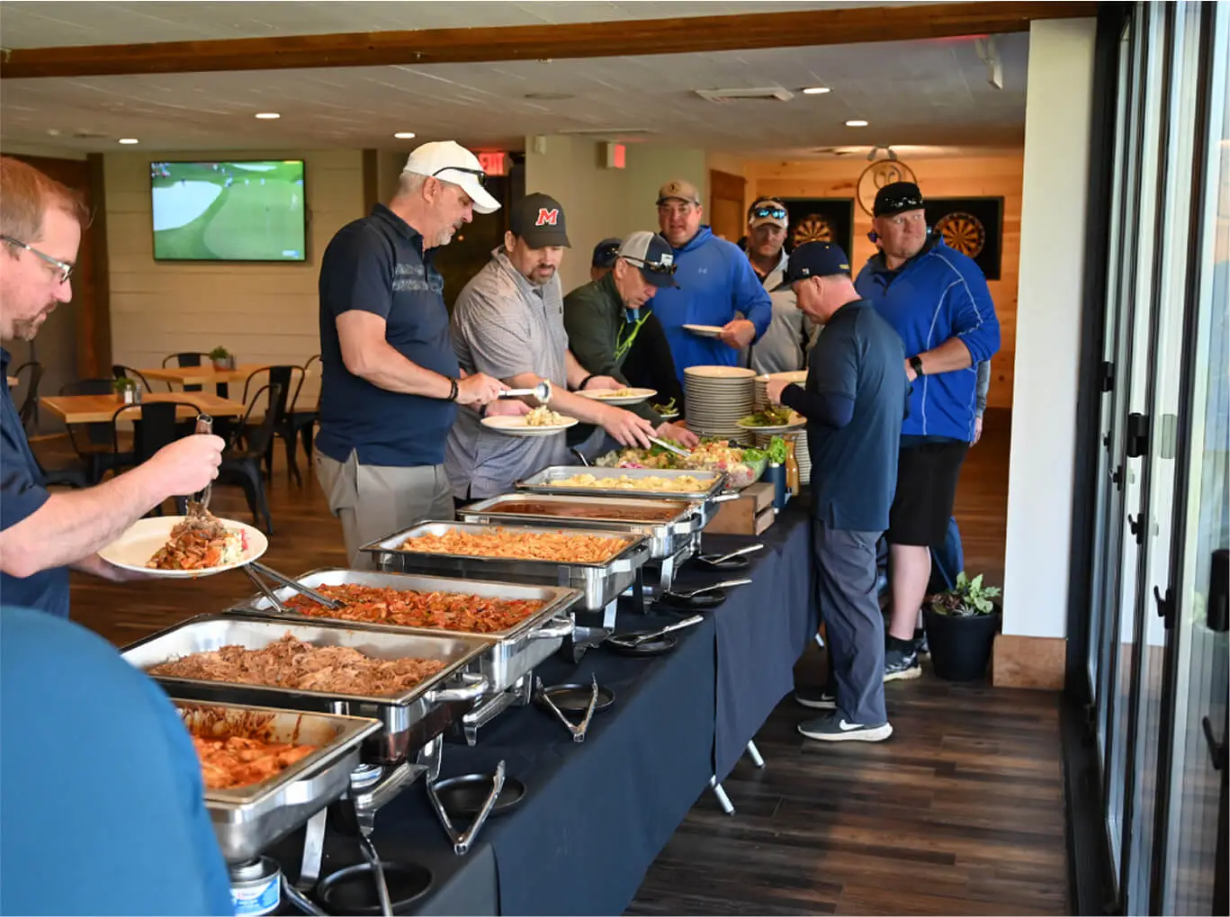 Group of people enjoying a meal together during a corporate event at Hef's Hut in Vernon, NJ, with lively conversation and shared dishes on the table.