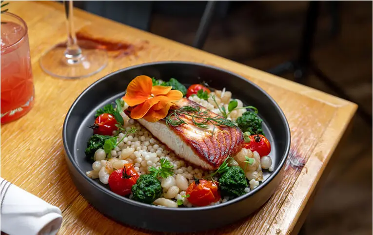 Close-up of a delicious fish and rice dish at Hef’s Hut Bar & Grill, showcasing vibrant colors and fresh ingredients.