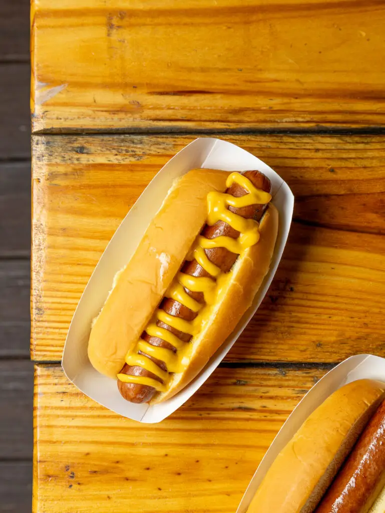 A close-up of a hot dog topped with mustard.