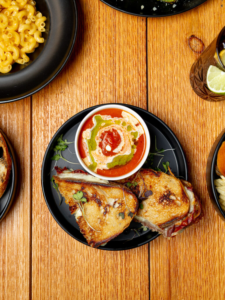 A close-up shot of Hef’s Hut’s signature soup with toast and herbs on the side.